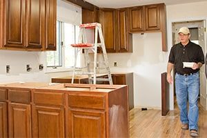 An image of a person walking in an unfurnished kitchen